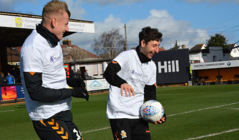 Two football players in CPSL Mind t shirts one of the players is holding a football