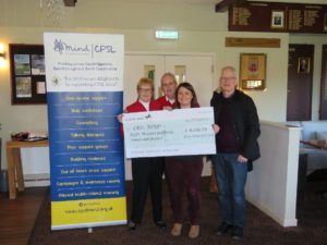 A group of people holding a cheque for CPSL Mind next to a CPSL Mind banner