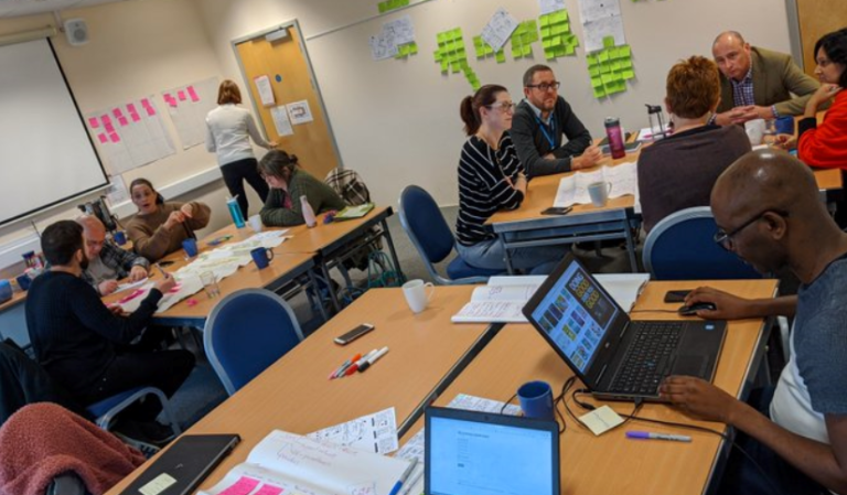 A group of people sat at three different tables having a training session