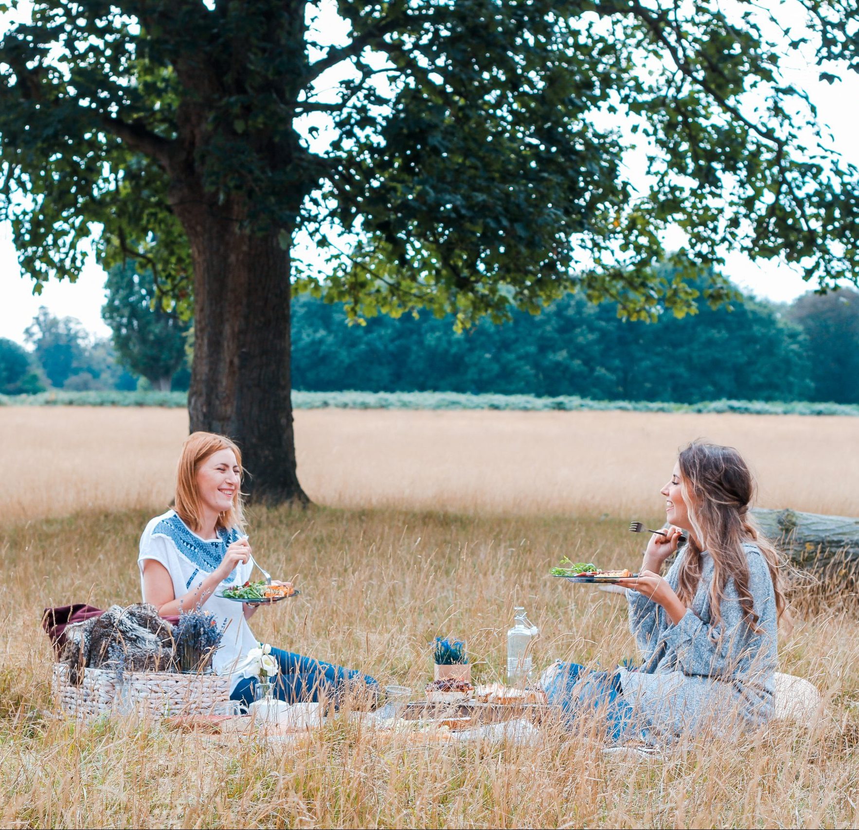 Two women in a field having a picnic