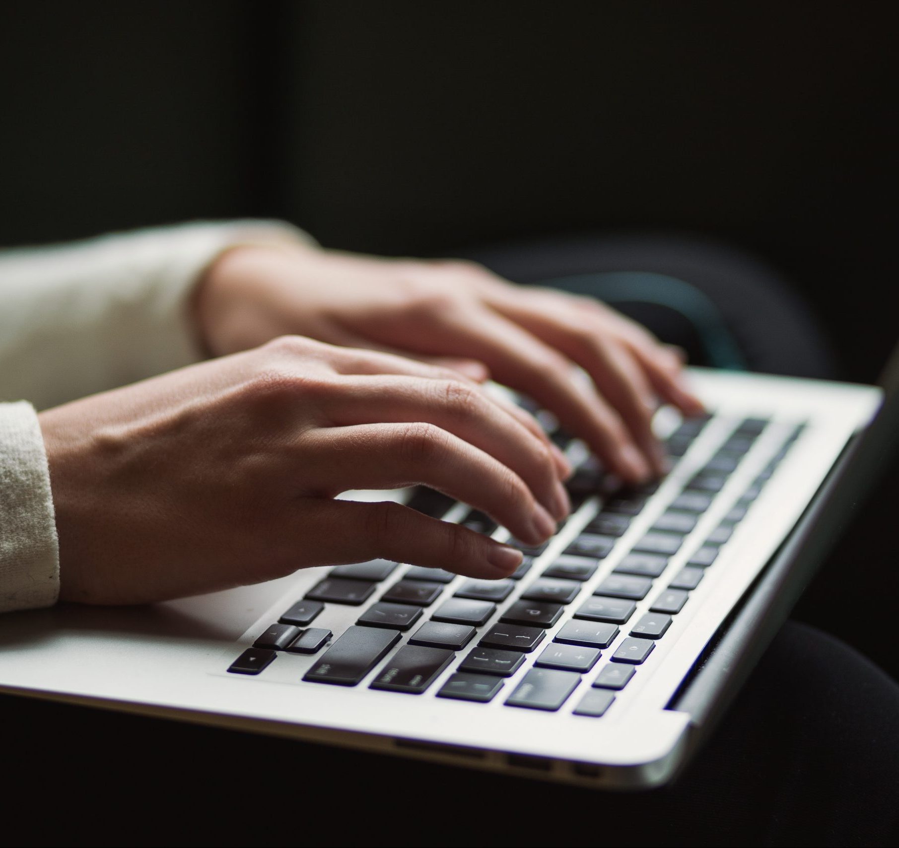 A woman typing on laptop