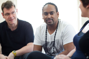 A white man sat next to a black man smiling at the camera