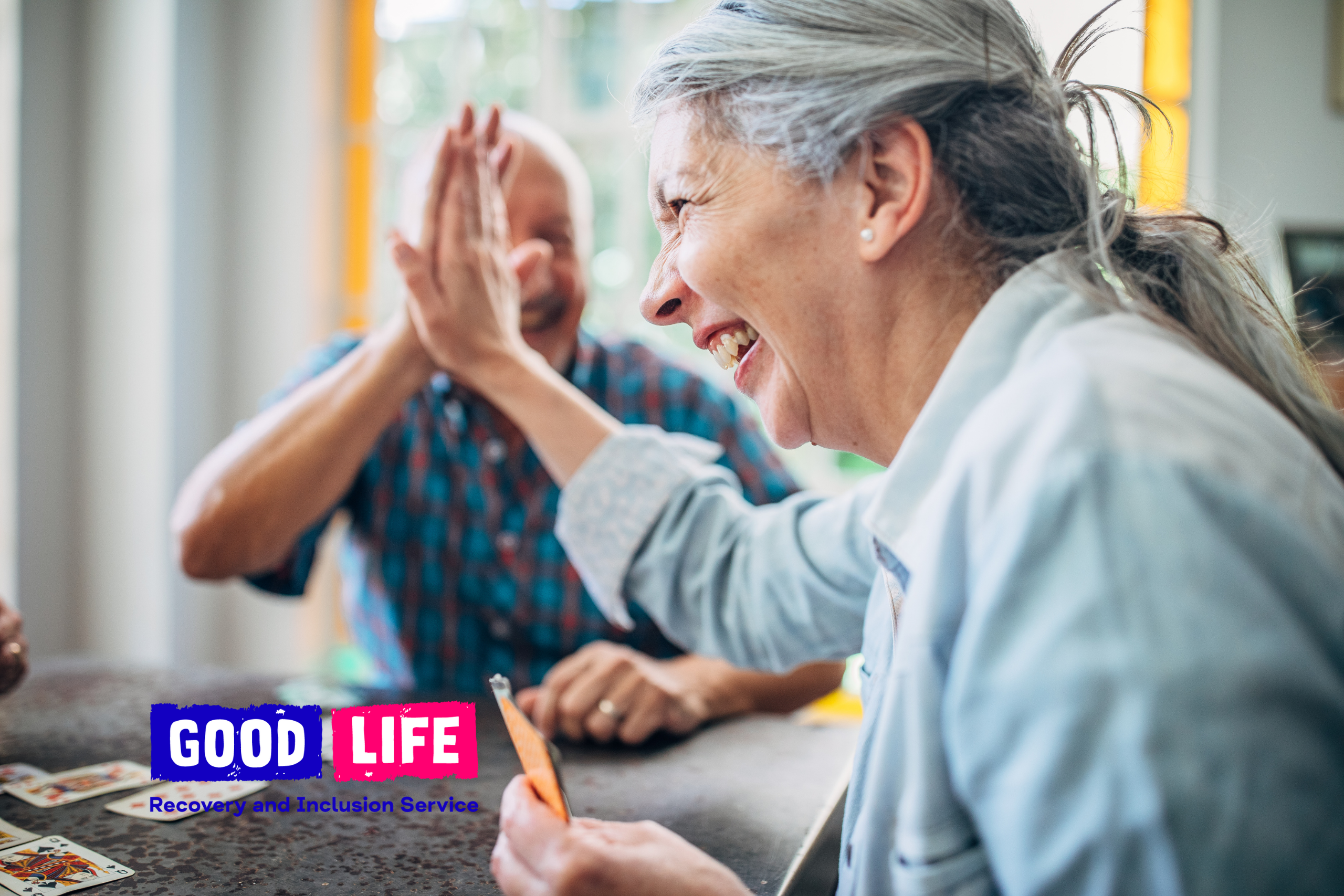 A man and a woman laughing while giving each other a high five