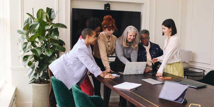 A group of women in an office looking at a laptop screen