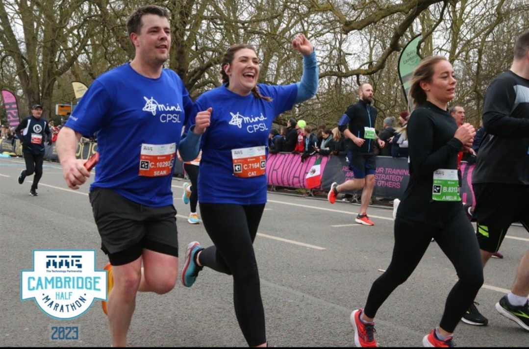 Two people running the Cambridge Half Marathon wearing CPSL Mind t-shirts